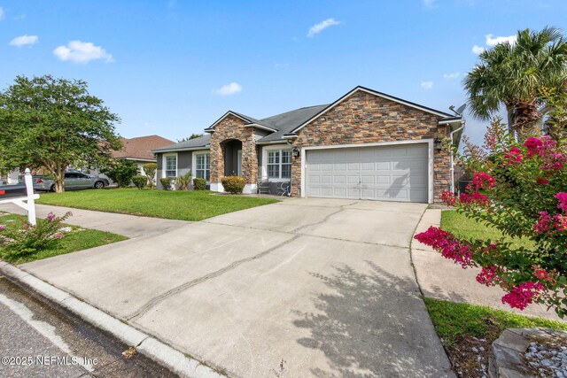 3592 Harrier Ct, Middleburg, FL 32068 - view of front of home with stone siding, a front yard, driveway, and an attached garage