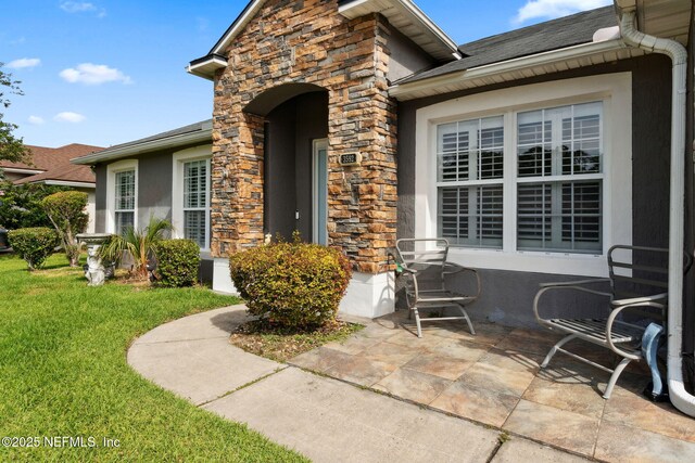 3592 Harrier Ct, Middleburg, FL 32068 - entrance to property featuring stone siding, a yard, and stucco siding