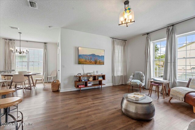 28 S Comares Ave, Saint Augustine Beach, FL 32080 - sitting room featuring a chandelier, wood finished floors, a textured ceiling, and baseboards