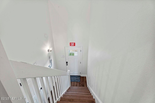 28 S Comares Ave, Saint Augustine Beach, FL 32080 - staircase with wood finished floors, baseboards, and a towering ceiling
