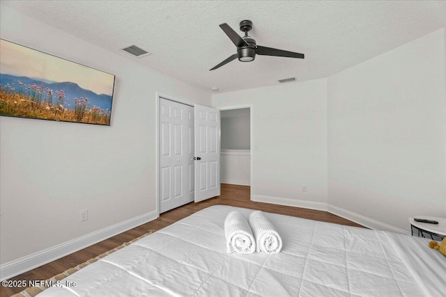 28 S Comares Ave, Saint Augustine Beach, FL 32080 - bedroom featuring wood finished floors, a textured ceiling, baseboards, a ceiling fan, and a closet