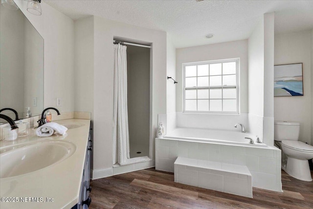 28 S Comares Ave, Saint Augustine Beach, FL 32080 - bathroom with toilet, a bath, double vanity, a stall shower, and wood finished floors