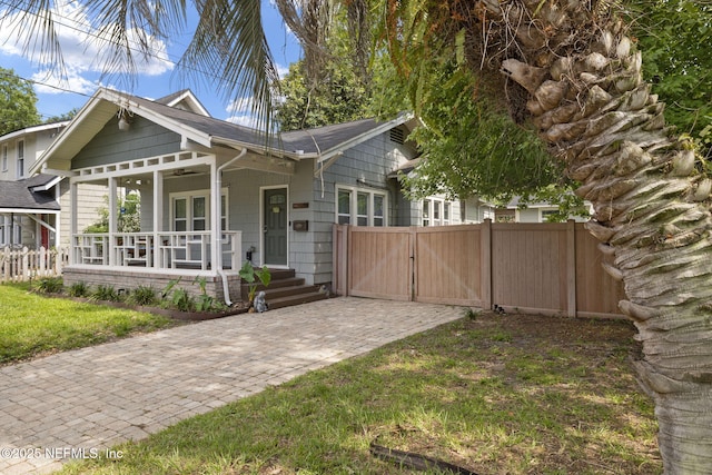 4524 Post St, Jacksonville, FL 32205 - view of front facade featuring covered porch, a gate, and roof with shingles
