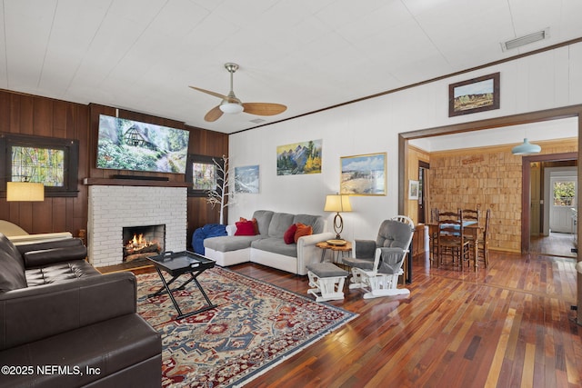 4524 Post St, Jacksonville, FL 32205 - living area with wood walls, hardwood / wood-style floors, a ceiling fan, and a fireplace