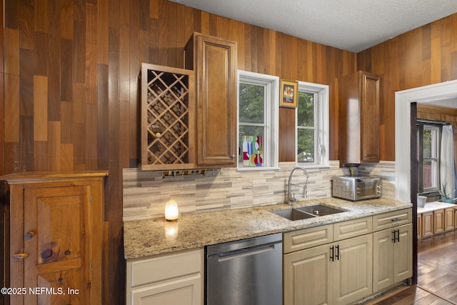 4524 Post St, Jacksonville, FL 32205 - kitchen with stainless steel dishwasher, a sink, tasteful backsplash, light stone counters, and wooden walls