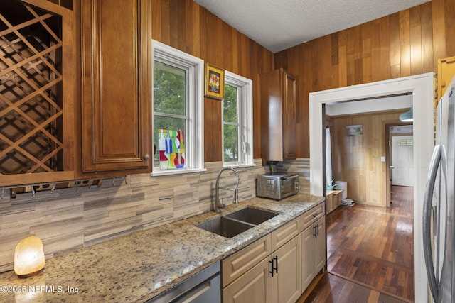 4524 Post St, Jacksonville, FL 32205 - kitchen featuring a sink, backsplash, wood walls, light stone countertops, and dark wood-type flooring