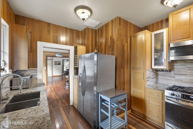 4524 Post St, Jacksonville, FL 32205 - kitchen featuring appliances with stainless steel finishes, a sink, decorative backsplash, a textured ceiling, and light stone countertops