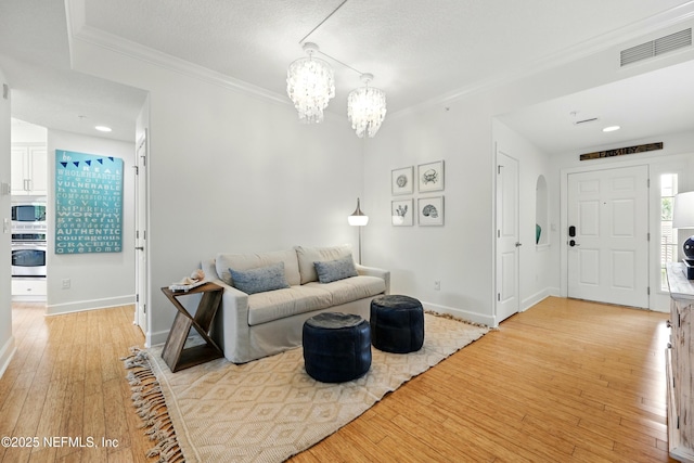 310 S Ocean Grande Dr Unit 205, Ponte Vedra Beach, FL 32082 - living room featuring ornamental molding, light wood-style flooring, a chandelier, and arched walkways