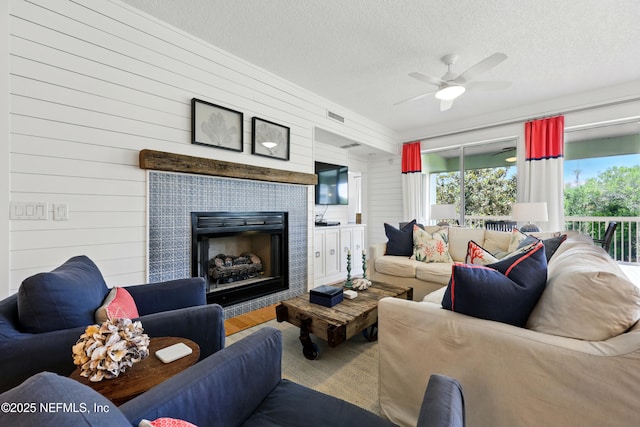 310 S Ocean Grande Dr Unit 205, Ponte Vedra Beach, FL 32082 - living area with a ceiling fan, a fireplace, a textured ceiling, wood walls, and wood finished floors