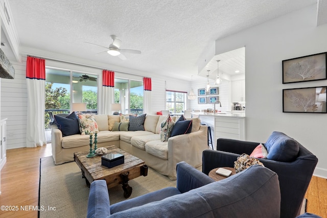 310 S Ocean Grande Dr Unit 205, Ponte Vedra Beach, FL 32082 - living room featuring light wood finished floors, a ceiling fan, and a textured ceiling