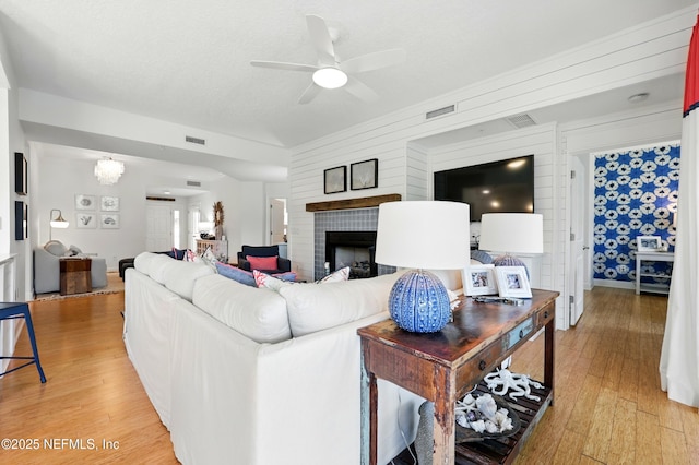 310 S Ocean Grande Dr Unit 205, Ponte Vedra Beach, FL 32082 - living room with light wood finished floors, ceiling fan, a fireplace, and a chandelier