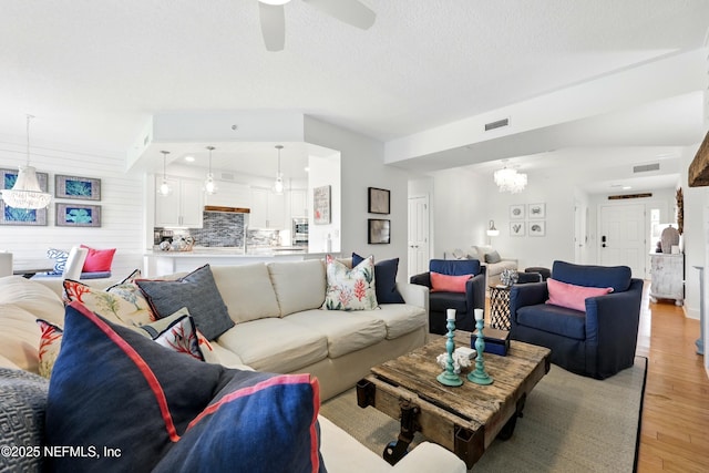 310 S Ocean Grande Dr Unit 205, Ponte Vedra Beach, FL 32082 - living area with light wood-style floors, a chandelier, and a ceiling fan