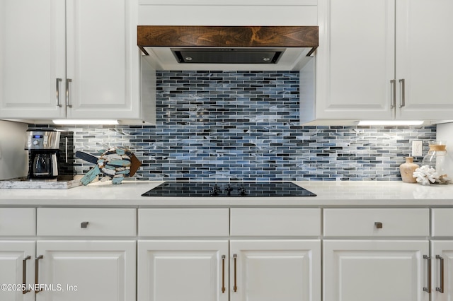 310 S Ocean Grande Dr Unit 205, Ponte Vedra Beach, FL 32082 - kitchen featuring white cabinets, light countertops, backsplash, and black electric cooktop