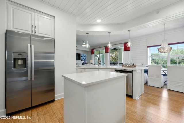 310 S Ocean Grande Dr Unit 205, Ponte Vedra Beach, FL 32082 - kitchen featuring appliances with stainless steel finishes, a center island, a peninsula, light wood-style floors, and light countertops