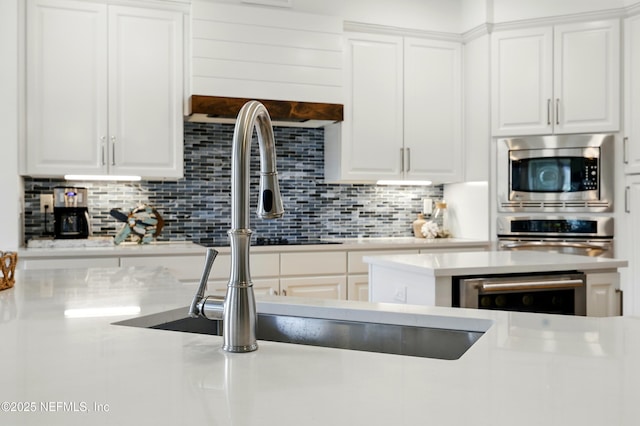 310 S Ocean Grande Dr Unit 205, Ponte Vedra Beach, FL 32082 - kitchen with appliances with stainless steel finishes, tasteful backsplash, white cabinets, and light countertops
