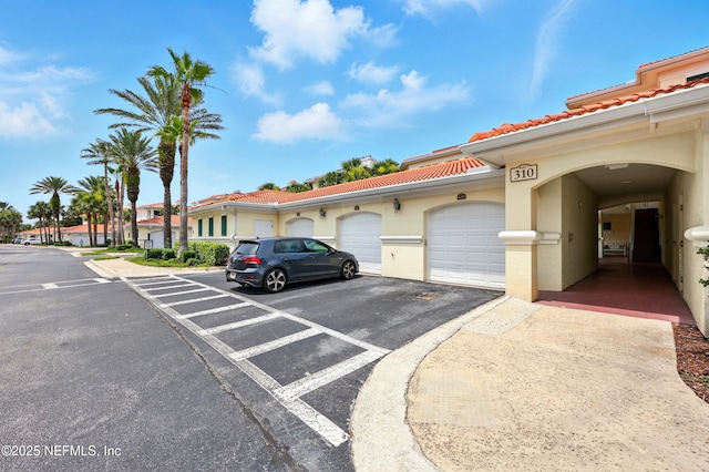 310 S Ocean Grande Dr Unit 205, Ponte Vedra Beach, FL 32082 - view of front facade with a tile roof, stucco siding, and community garages