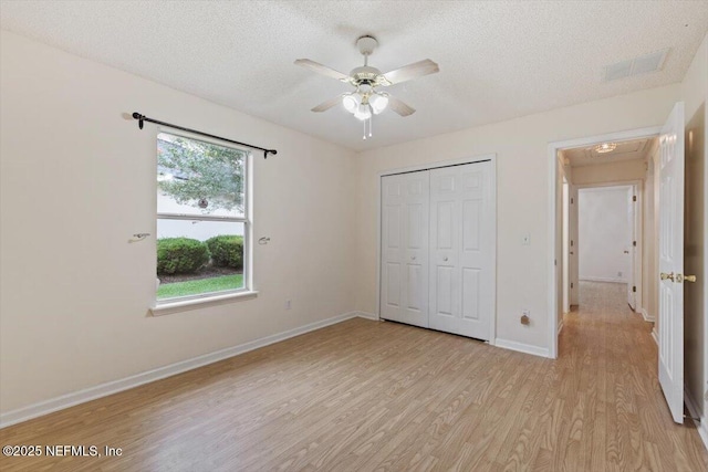 2888 Majestic Oaks Ln, Green Cove Springs, FL 32043 - unfurnished bedroom with light wood-style floors, a textured ceiling, a closet, and a ceiling fan