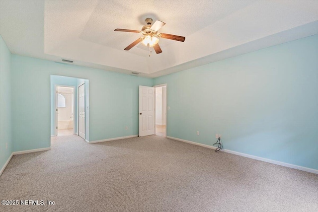 2888 Majestic Oaks Ln, Green Cove Springs, FL 32043 - unfurnished bedroom with carpet flooring, a tray ceiling, a ceiling fan, ensuite bathroom, and a textured ceiling