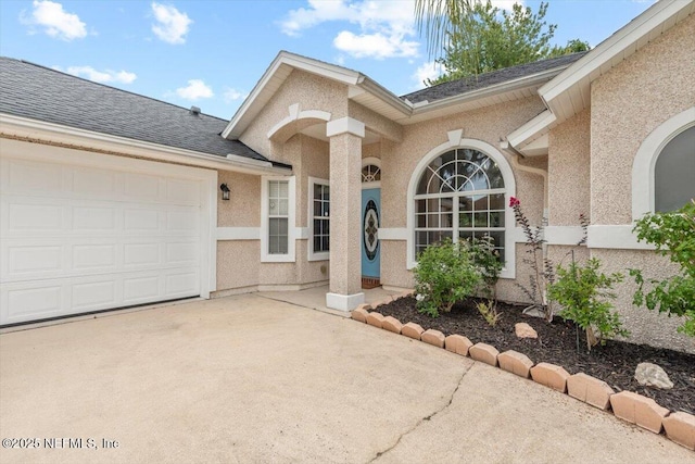 2888 Majestic Oaks Ln, Green Cove Springs, FL 32043 - entrance to property featuring a garage, concrete driveway, stucco siding, and roof with shingles