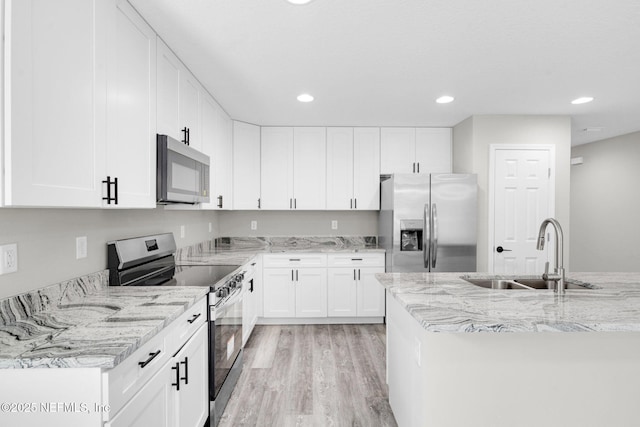 1731 W 28th St, Jacksonville, FL 32209 - kitchen with appliances with stainless steel finishes, a sink, light wood-style flooring, white cabinets, and recessed lighting