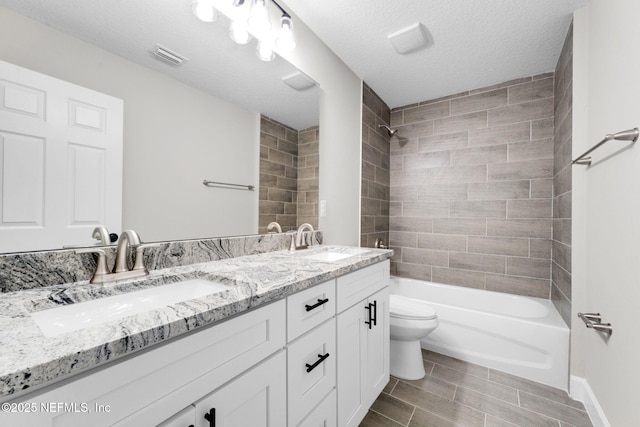 1731 W 28th St, Jacksonville, FL 32209 - full bath featuring double vanity, toilet, bathtub / shower combination, baseboards, and a textured ceiling