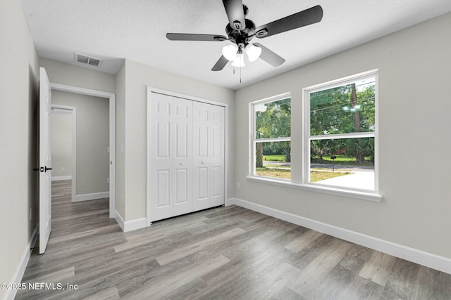 1731 W 28th St, Jacksonville, FL 32209 - unfurnished bedroom with wood finished floors, baseboards, a closet, and ceiling fan
