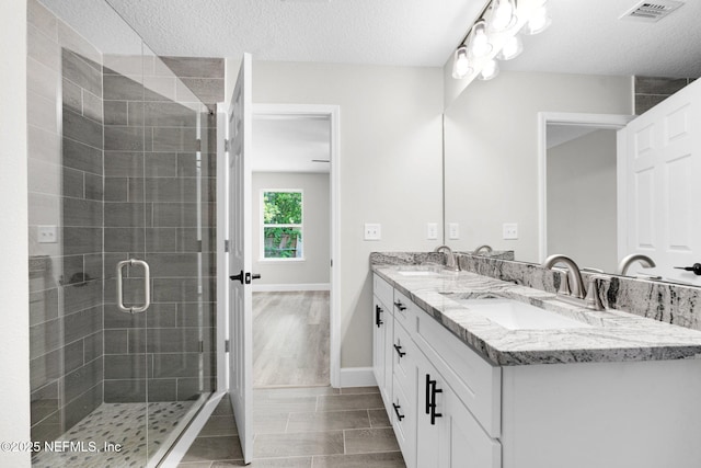 1731 W 28th St, Jacksonville, FL 32209 - bathroom with double vanity, a stall shower, a textured ceiling, and baseboards