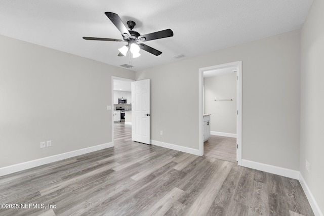 1731 W 28th St, Jacksonville, FL 32209 - unfurnished bedroom featuring wood finished floors, baseboards, connected bathroom, and ceiling fan