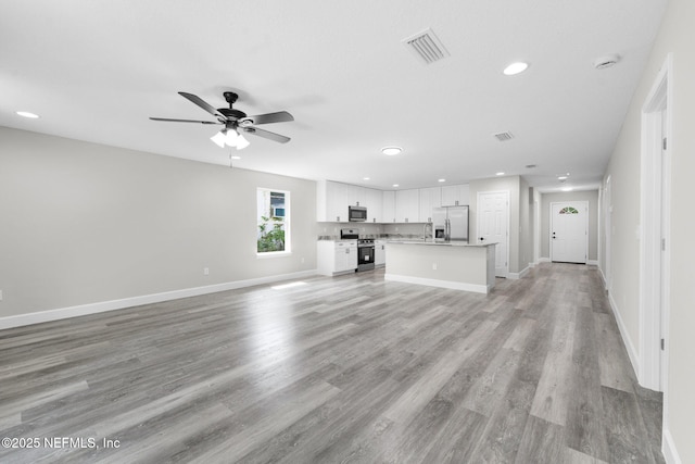 1731 W 28th St, Jacksonville, FL 32209 - unfurnished living room featuring ceiling fan, recessed lighting, baseboards, and light wood-type flooring