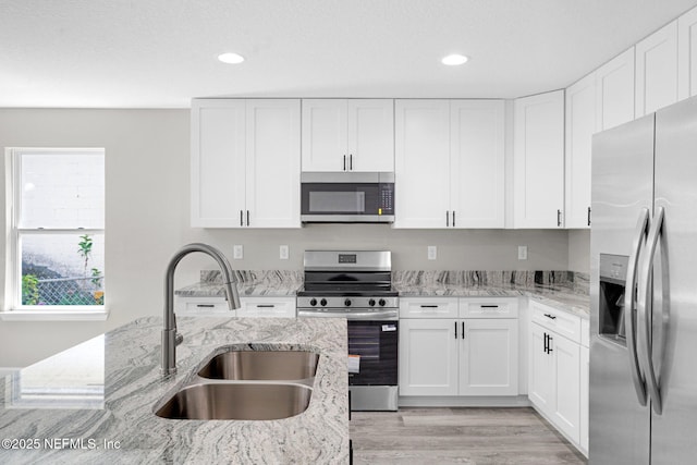 1731 W 28th St, Jacksonville, FL 32209 - kitchen with appliances with stainless steel finishes, a sink, light wood-style flooring, white cabinets, and recessed lighting