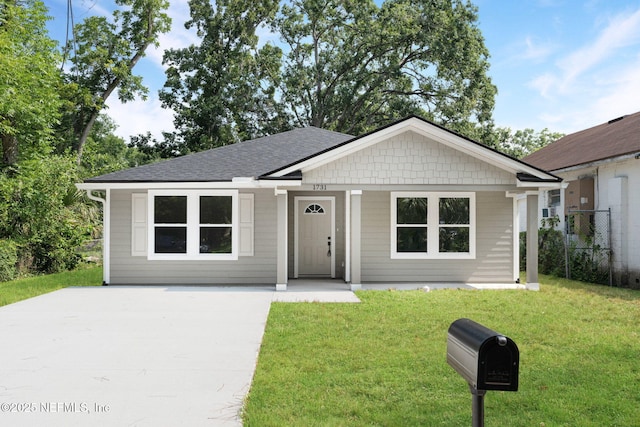1731 W 28th St, Jacksonville, FL 32209 - view of front of property featuring a front yard, a shingled roof, and driveway