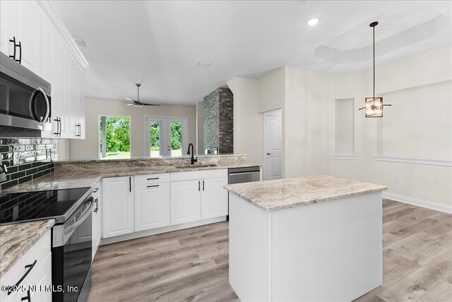1790 N Lakeshore Dr, Fleming Island, FL 32003 - kitchen with appliances with stainless steel finishes, a sink, light wood-style floors, white cabinetry, and tasteful backsplash