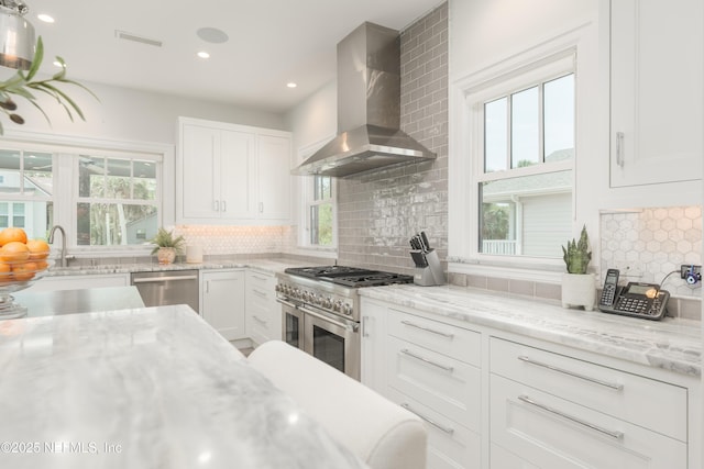 365 8th St, Atlantic Beach, FL 32233 - kitchen with island range hood, appliances with stainless steel finishes, healthy amount of natural light, white cabinets, and recessed lighting