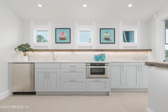 365 8th St, Atlantic Beach, FL 32233 - kitchen featuring stainless steel oven, gray cabinets, decorative backsplash, light stone counters, and recessed lighting