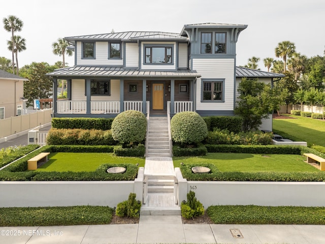 365 8th St, Atlantic Beach, FL 32233 - view of front facade featuring a standing seam roof, a metal roof, stairs, covered porch, and a front lawn