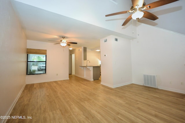 1266 Mayport Landing Cir, Jacksonville, FL 32233 - unfurnished living room featuring a ceiling fan, light wood-type flooring, a sink, and baseboards