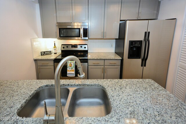 1266 Mayport Landing Cir, Jacksonville, FL 32233 - kitchen with appliances with stainless steel finishes, a sink, light stone countertops, and tasteful backsplash