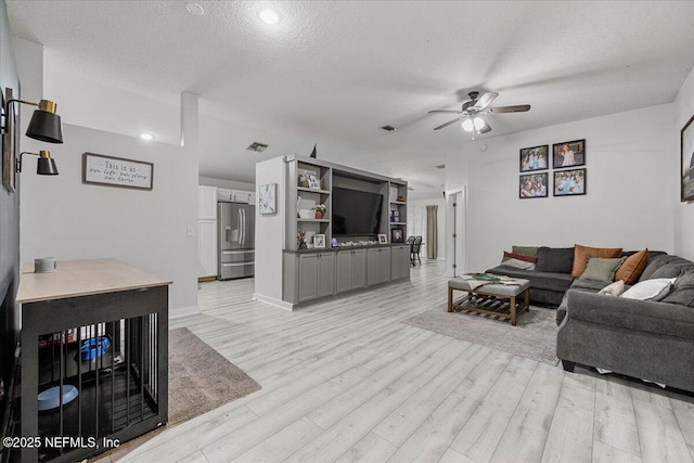 11214 Bentley Trace Ln E, Jacksonville, FL 32257 - living area with ceiling fan, light wood-style floors, a textured ceiling, and baseboards