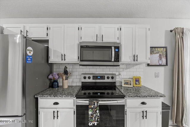 11214 Bentley Trace Ln E, Jacksonville, FL 32257 - kitchen with stainless steel appliances, white cabinetry, backsplash, a textured ceiling, and dark stone countertops