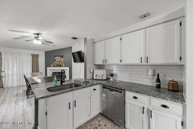 11214 Bentley Trace Ln E, Jacksonville, FL 32257 - kitchen with stainless steel dishwasher, a sink, a ceiling fan, white cabinetry, and a textured ceiling