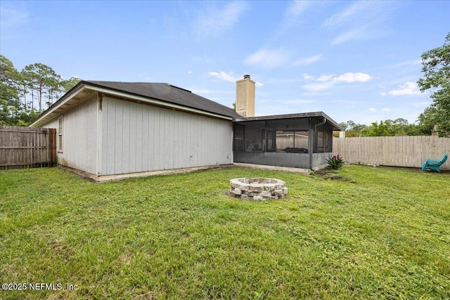 11214 Bentley Trace Ln E, Jacksonville, FL 32257 - rear view of house with a chimney, a fire pit, and a sunroom