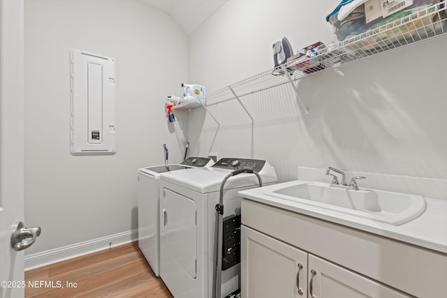 46 Hydrilla Ct, Saint Augustine, FL 32095 - laundry room featuring electric panel, washing machine and clothes dryer, light wood-type flooring, and cabinet space