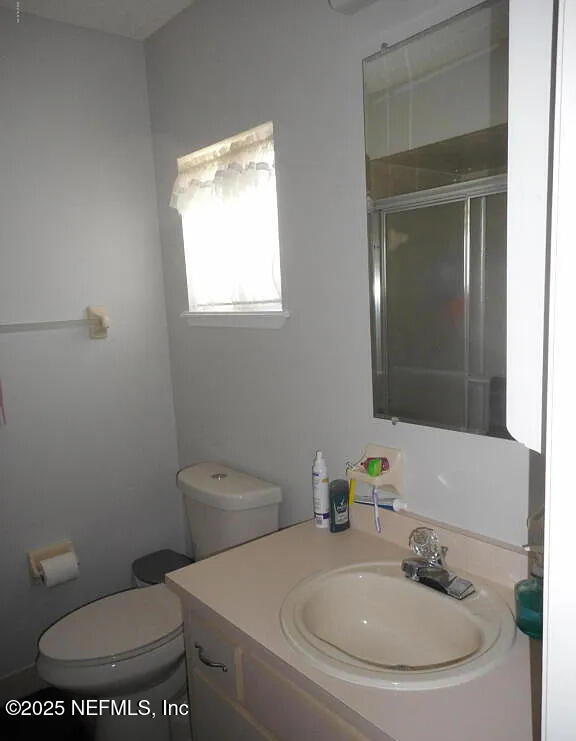 7670 SW 112th Ln, Ocala, FL 34476 - bathroom featuring vanity, a shower with shower door, and toilet