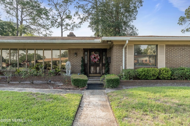 2364 Smullian Trl S, Jacksonville, FL 32217 - view of front of house with brick siding, a front lawn, and a chimney