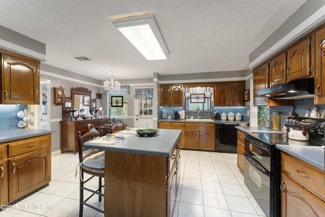 2364 Smullian Trl S, Jacksonville, FL 32217 - kitchen with black appliances, under cabinet range hood, a kitchen bar, a chandelier, and light tile patterned floors