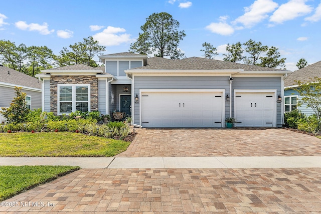 85600 Stonehurst Pkwy, Fernandina Beach, FL 32034 - view of front facade with decorative driveway, a garage, a front lawn, and stone siding