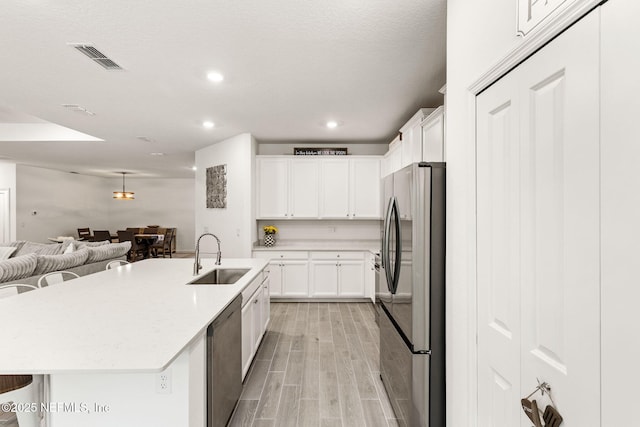 85600 Stonehurst Pkwy, Fernandina Beach, FL 32034 - kitchen with appliances with stainless steel finishes, a sink, open floor plan, light wood finished floors, and a spacious island