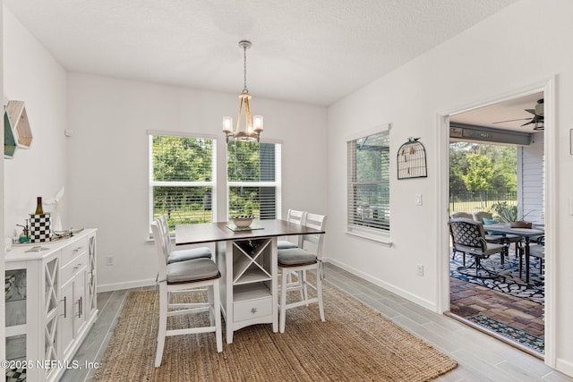 85600 Stonehurst Pkwy, Fernandina Beach, FL 32034 - dining space with a chandelier, a textured ceiling, baseboards, and a ceiling fan
