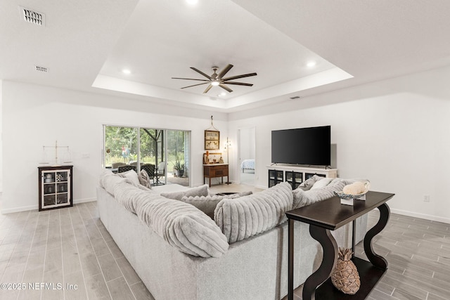 85600 Stonehurst Pkwy, Fernandina Beach, FL 32034 - living area with ceiling fan, a tray ceiling, baseboards, recessed lighting, and wood tiled floors