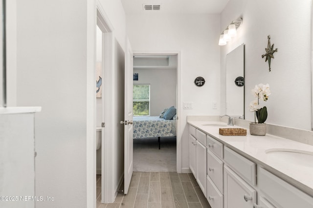 85600 Stonehurst Pkwy, Fernandina Beach, FL 32034 - bathroom with double vanity, ensuite bathroom, wood tiled floors, and toilet